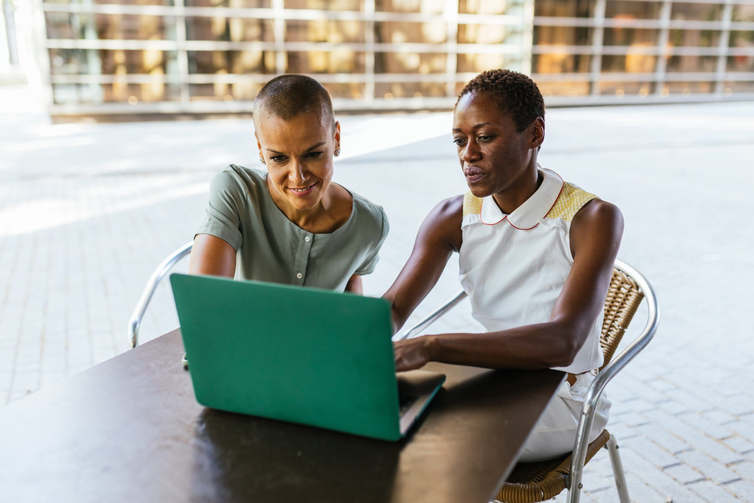 Multicultural,Teamwork,,Two,Women,Working,With,Laptop,At,Bar,Terrace One on One Coaching